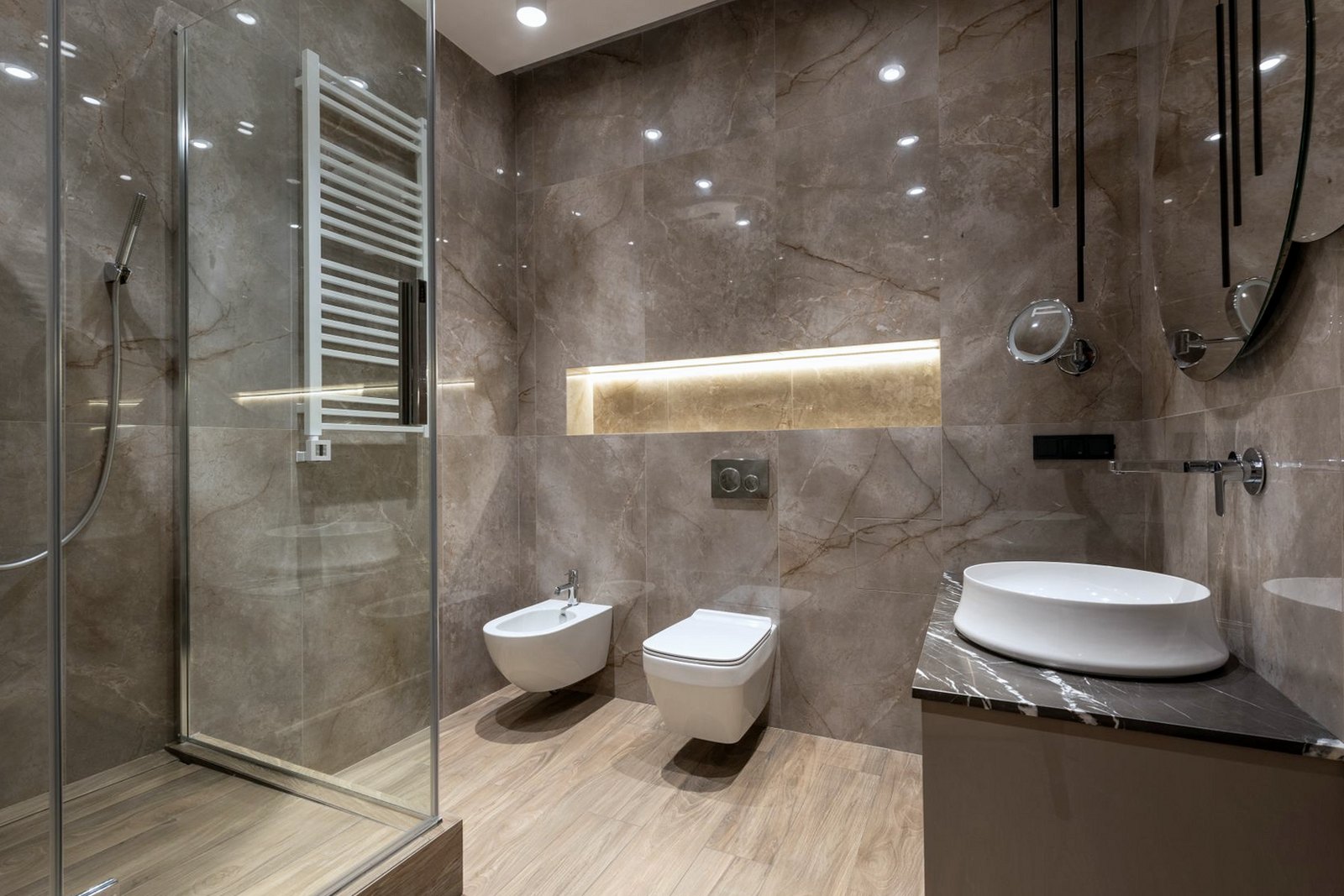 Large-format stone wall tiles in a shower room with a basin